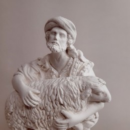 Pastor arrodillado con borrego